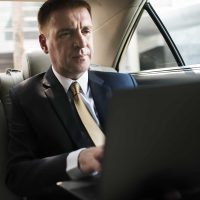 businessman-inside-a-car-working-on-his-laptop.jpg